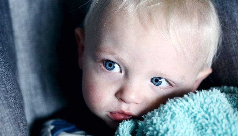 baby beside green textile